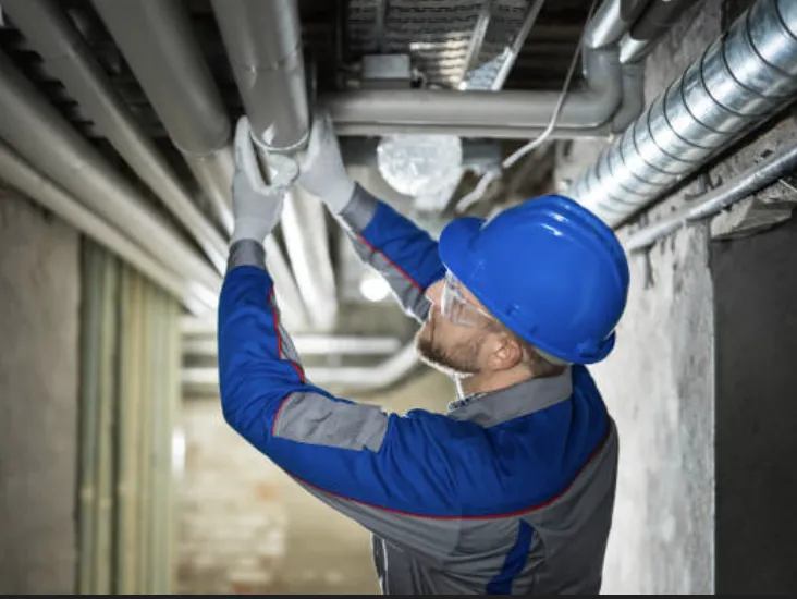 a man wearing a hard hat and holding a gun