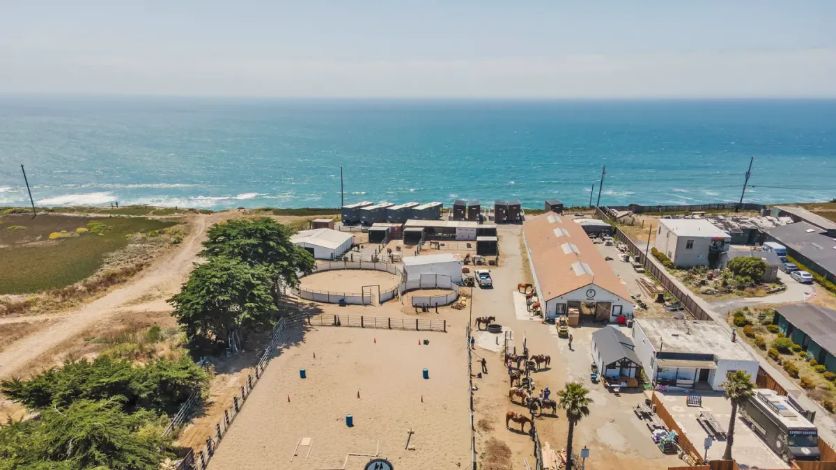 Ocean View Stables from the air, with the arena, the barns and the Pacific beyond