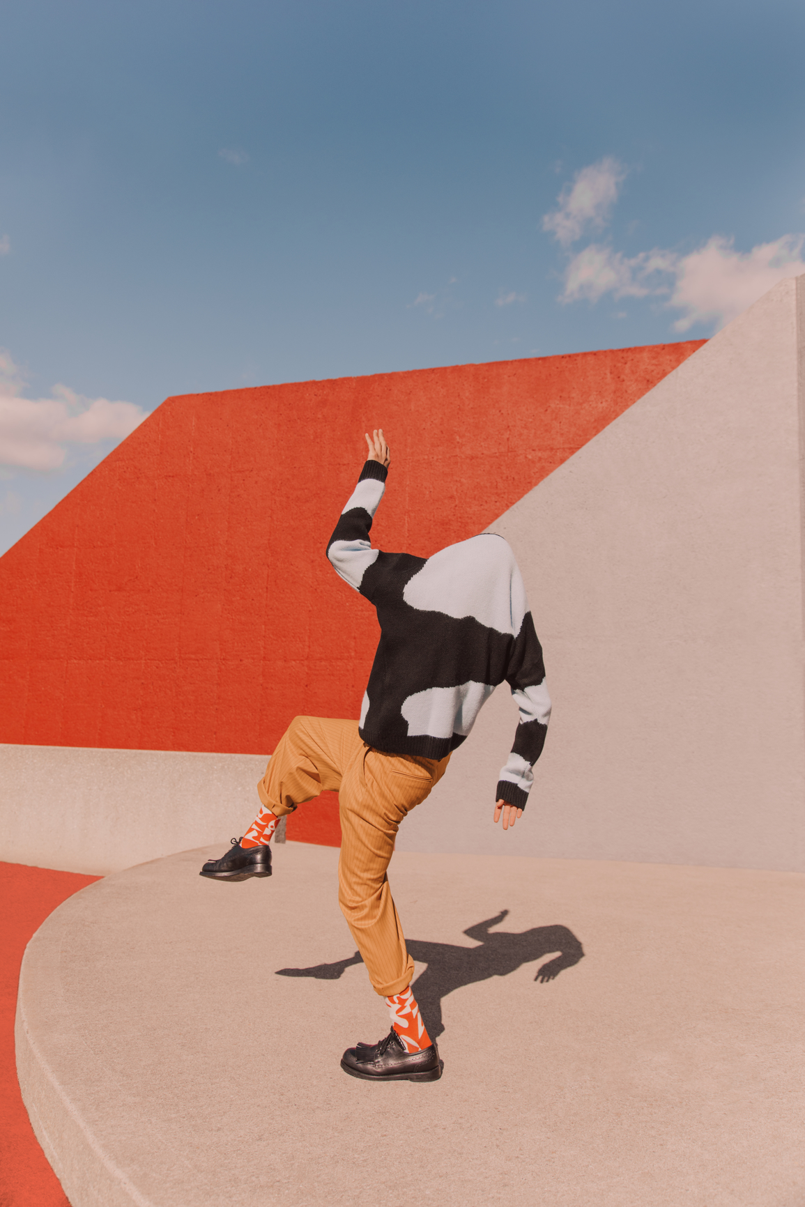 Playful person dancing with their sweater over their head to illustration the lack of LLM Visibility