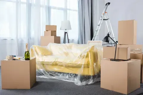 Foreclosure cleanout with boxed belongings and covered furniture by West Linn Junk Removal.