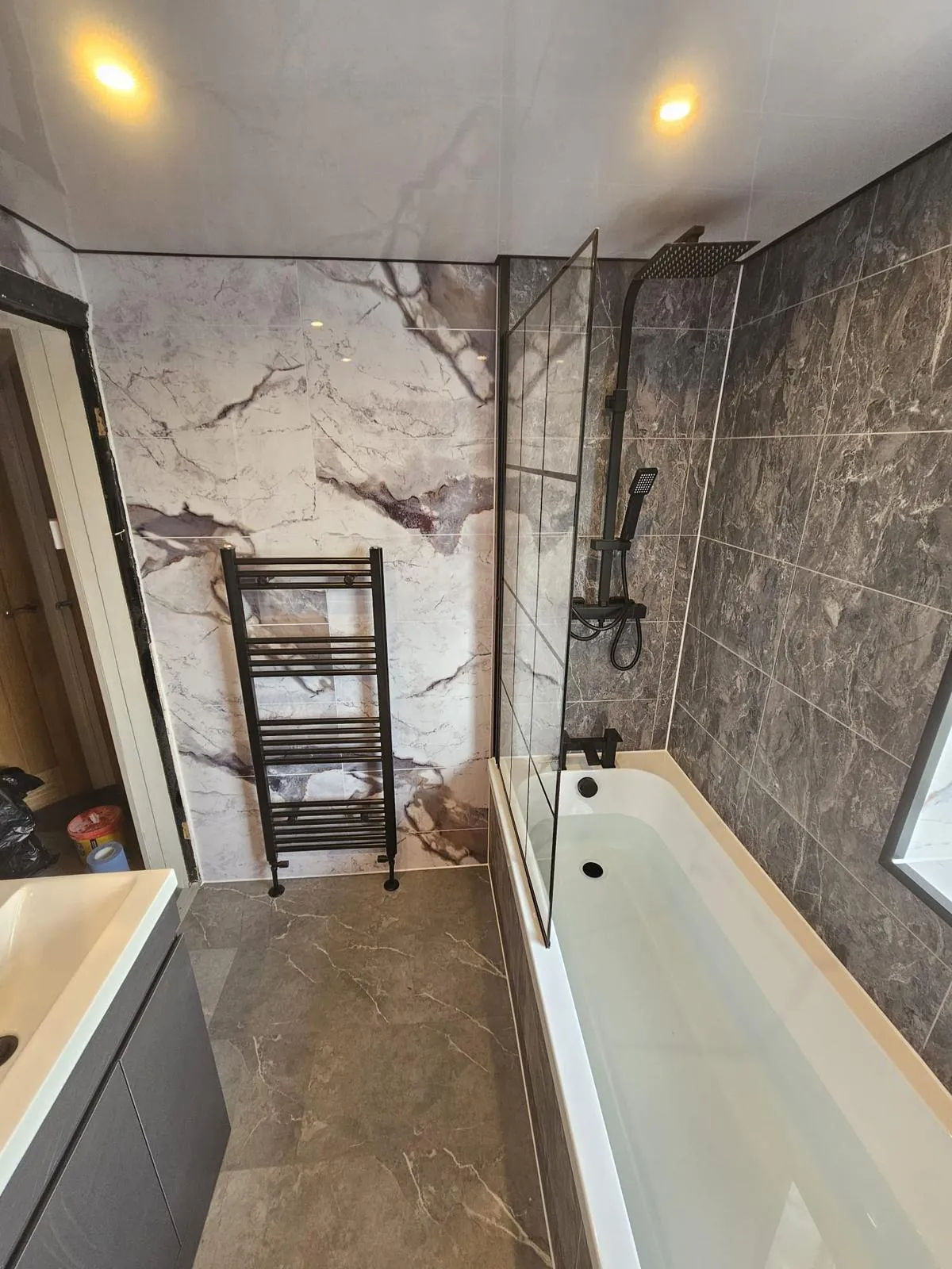 a bathroom with a toilet and a tiled wall