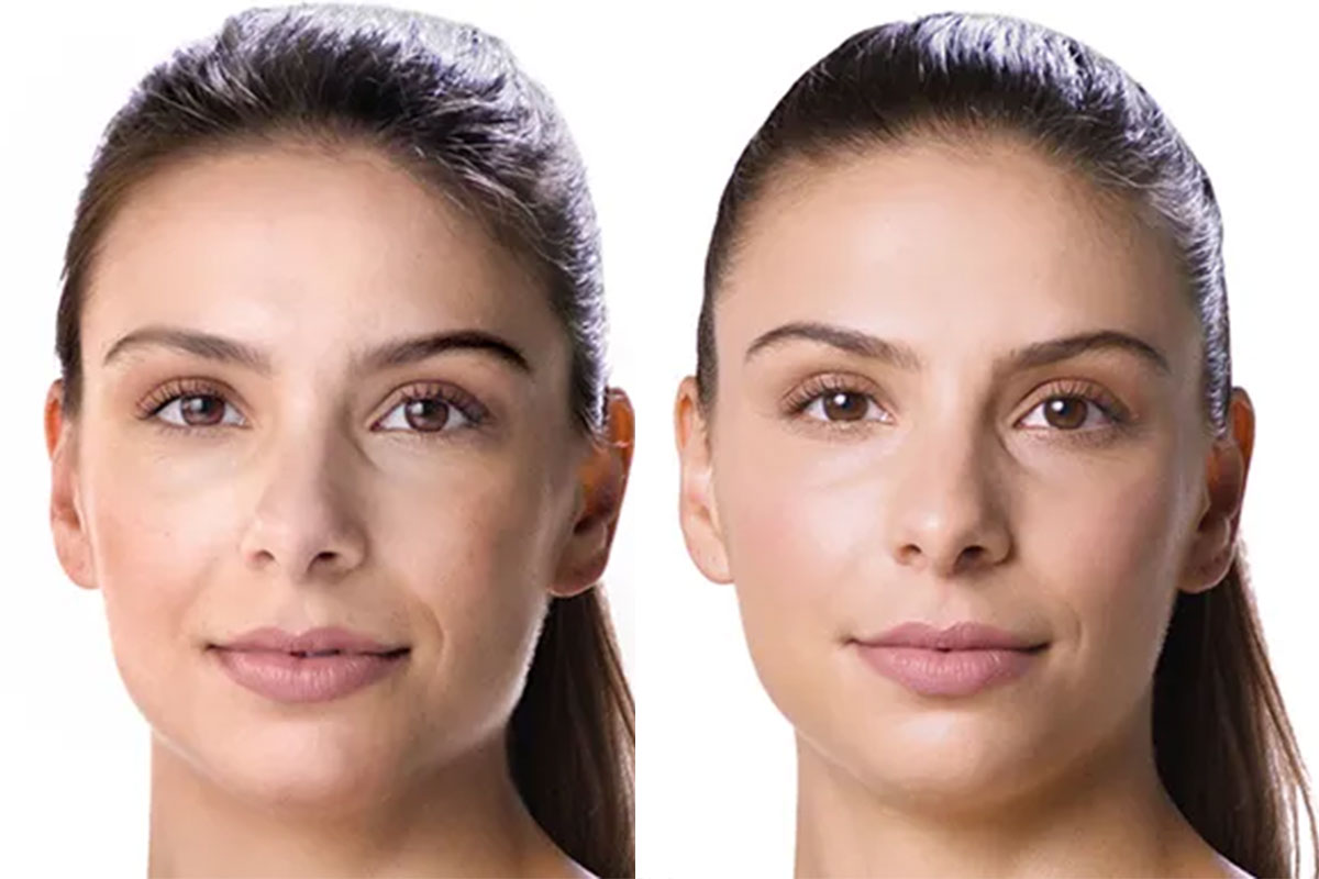 person holding clear glass bottle