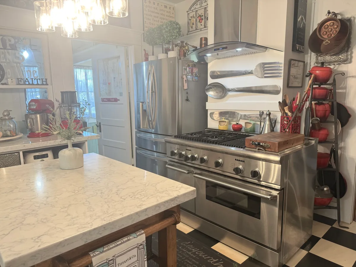 Modern heirloom kitchen with warm light and wooden shelves