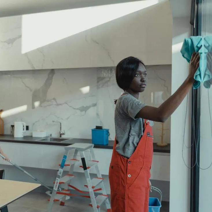 Professional house cleaning service in Christchurch with a cleaner wiping a glass surface