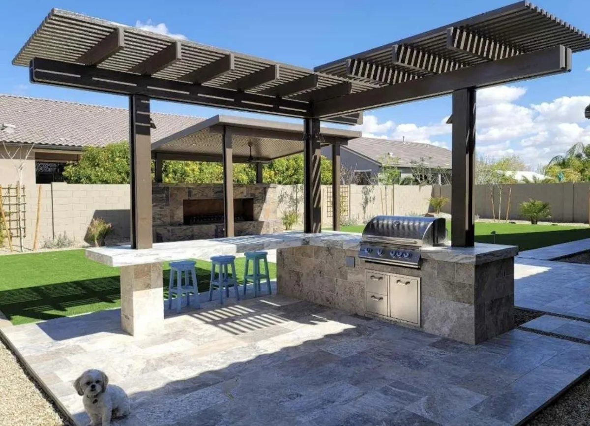 Contemporary metal pergola with horizontal slats over an outdoor kitchen and bar area with built-in grill.