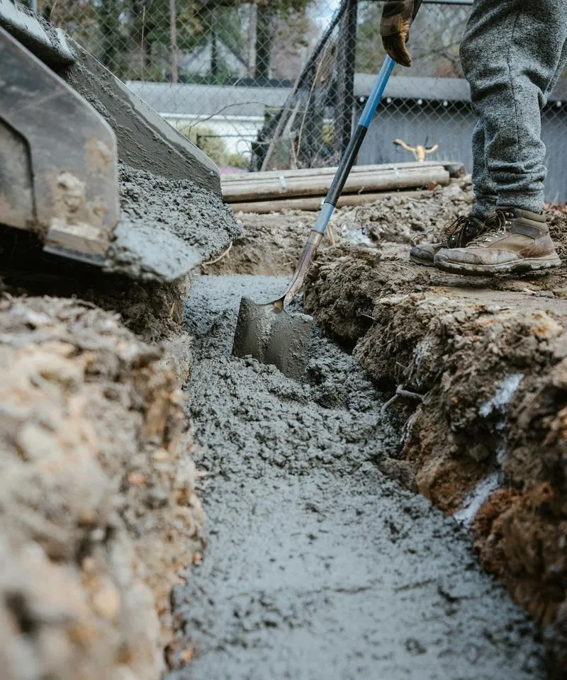 CR Concrete Construction workers pouring concrete into position on a driveway installation.