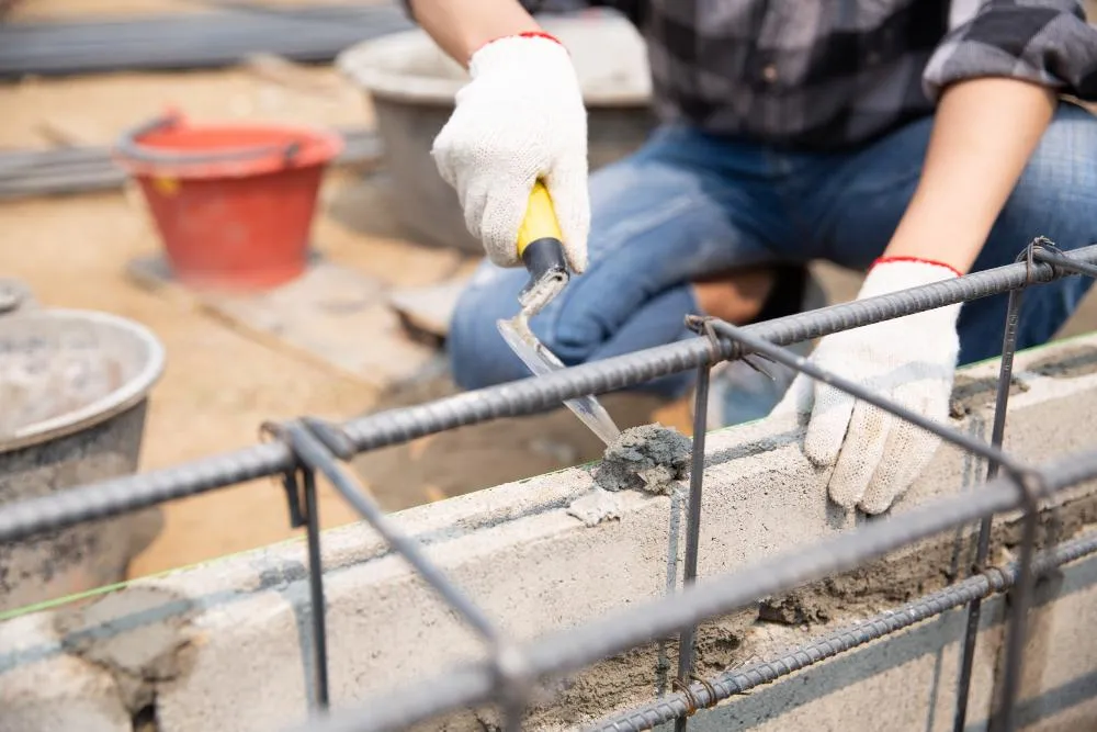 CR Concrete Construction worker laying brick for retaining wall