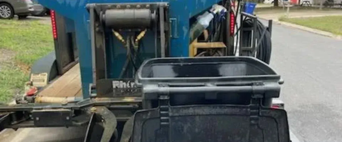 Trash bin cleaning service washing residential garbage bin with professional equipment