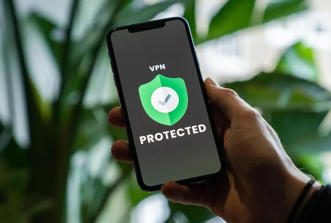 Person holding a phone with a VPN protection icon, symbolizing governance, regulatory compliance, and digital security.