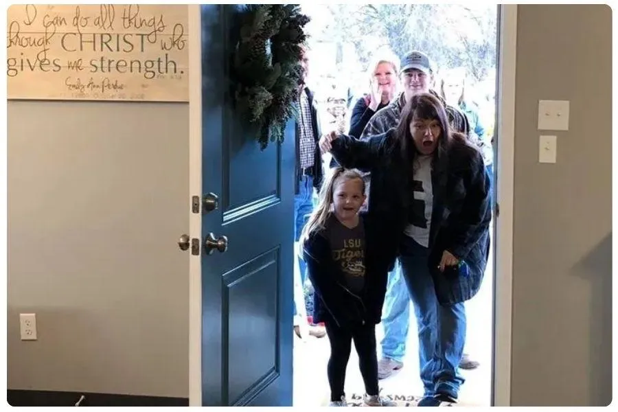 Family entering a newly installed front door, smiling at camera