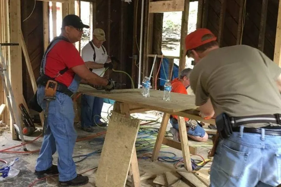 Volunteers framing interior walls with insulation visible
