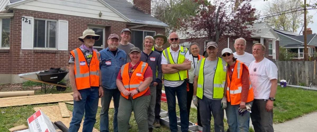 Group photo of a corporate volunteer team outside a finished project
