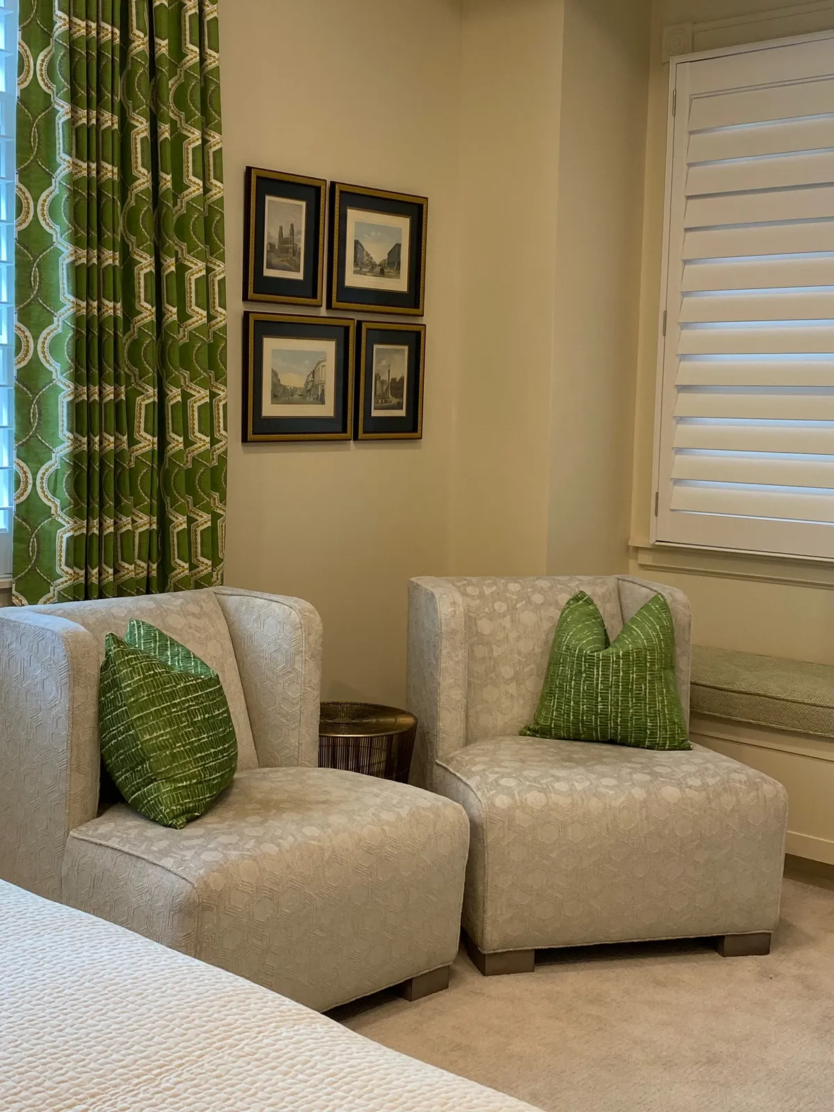 Pair of light gray sofas with green pillows and landscape prints