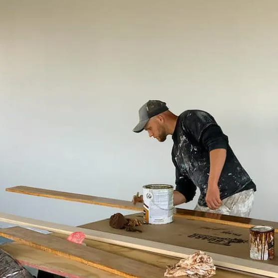 man staining wood