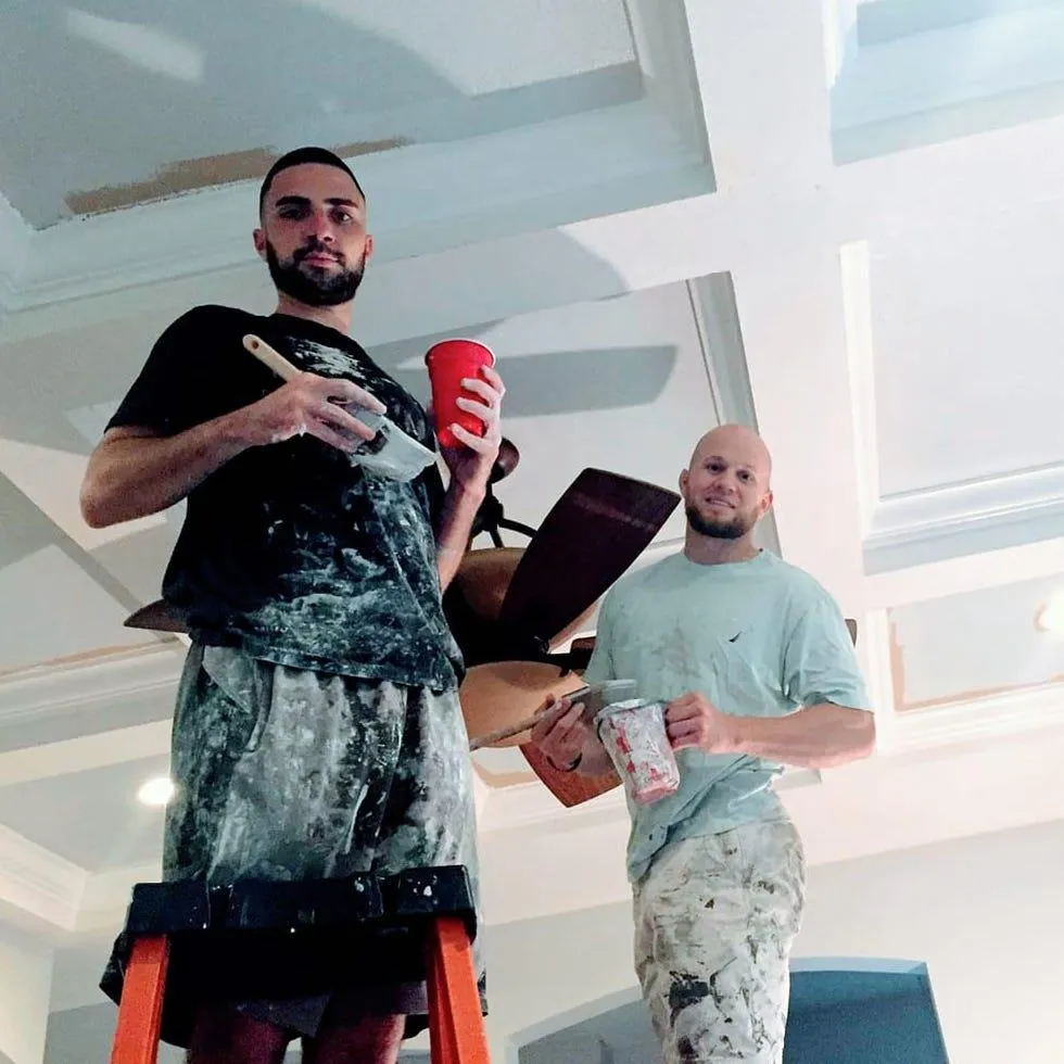 men painting a ceiling