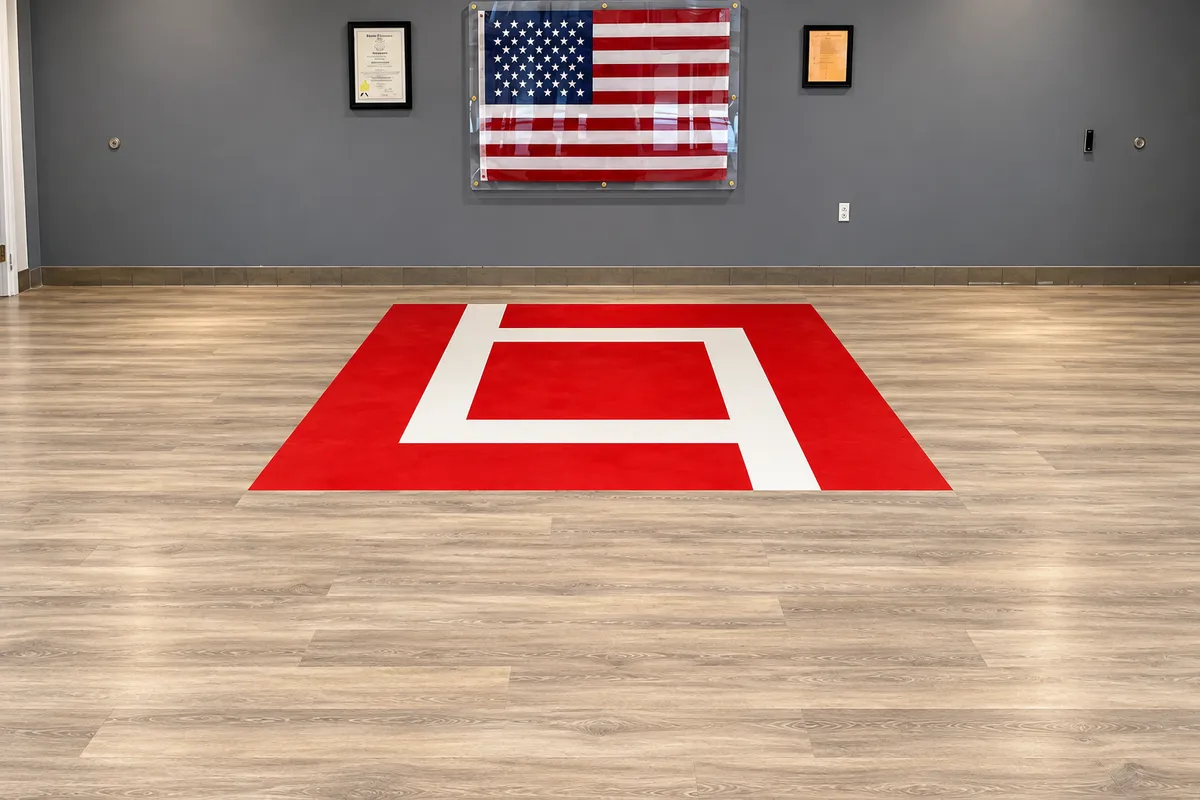 Wood-look commercial flooring with a red geometric design in a large room