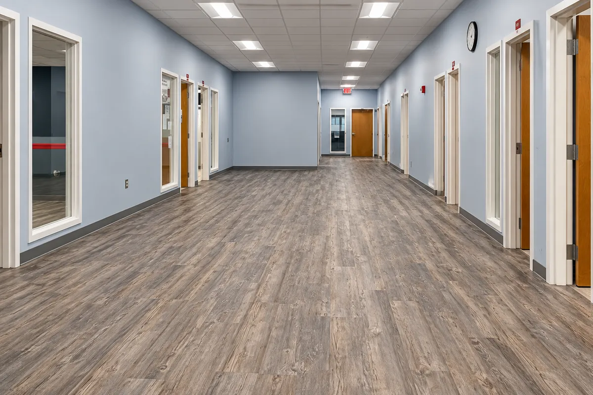 Gray wood-look flooring in a commercial hallway with multiple doorways
