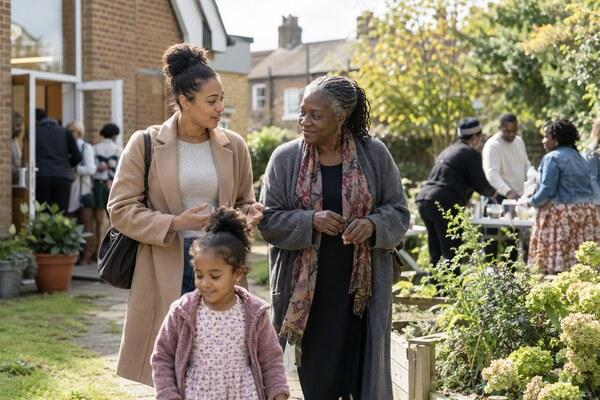 A church leader walking with a mother and child after a community gathering in South London.