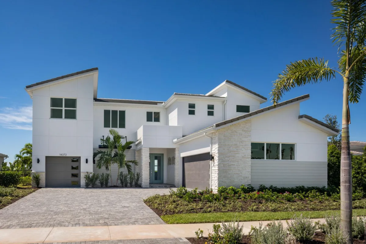 white and gray house near green trees under blue sky during daytime