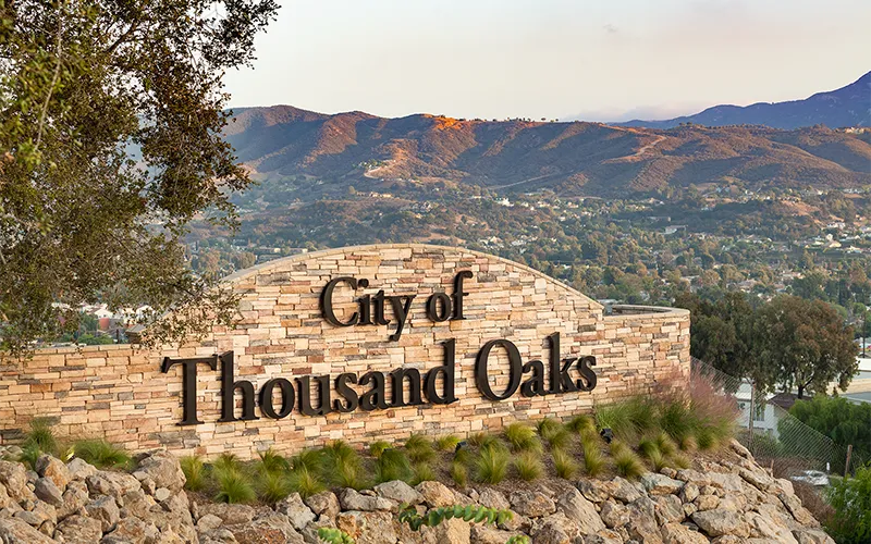 City of Thousand Oaks welcome sign with scenic mountain views.