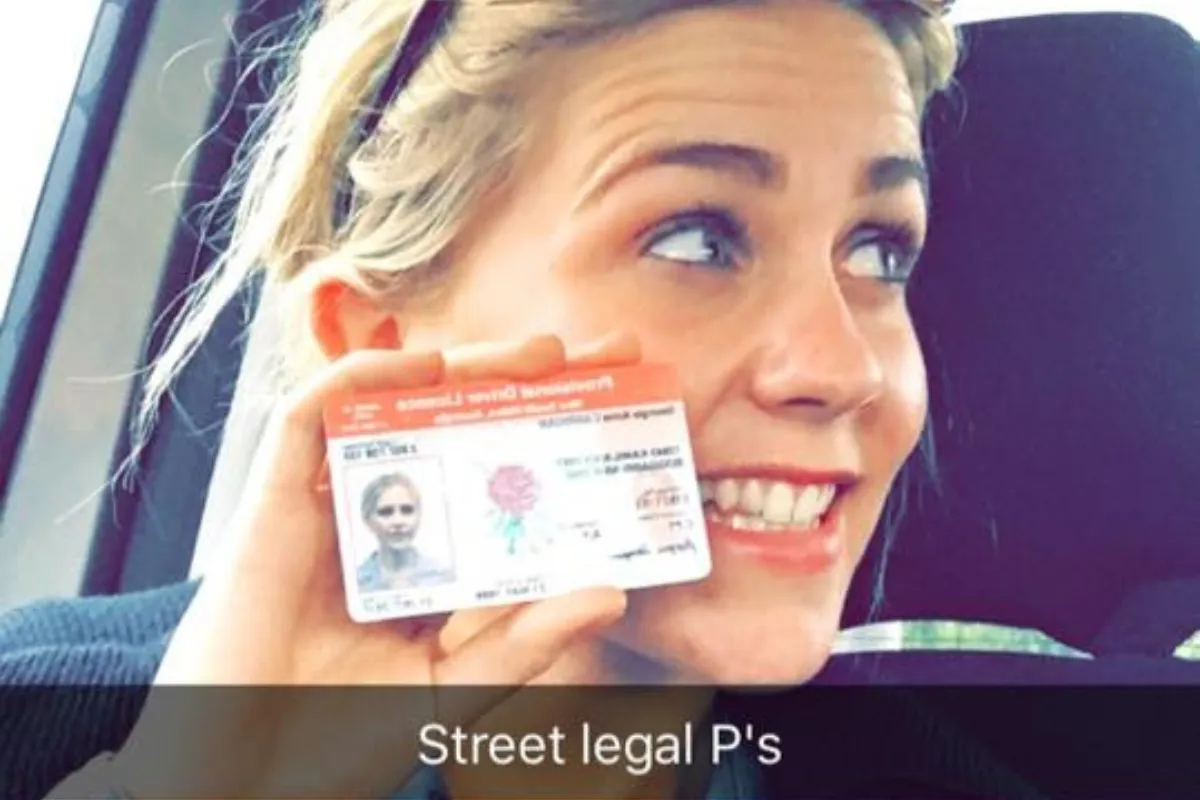 Driving student holding her P plates after passing her test with Driving Miss Del.