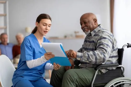 Doctor consults with an elderly patient on a couch.