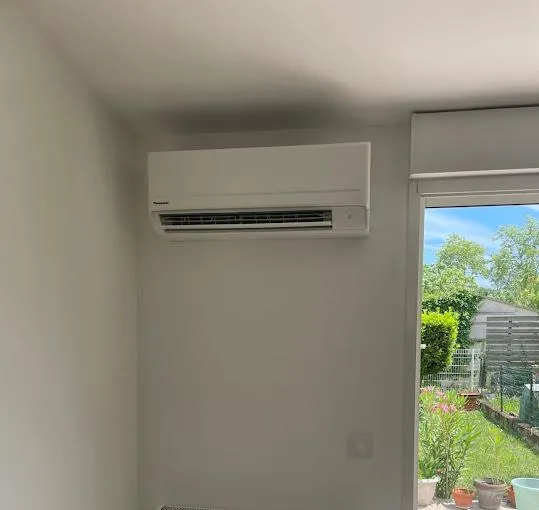 Installation résidentielle en Occitanie, toit avec panneaux solaires et techniciens au travail, vue trois-quarts.