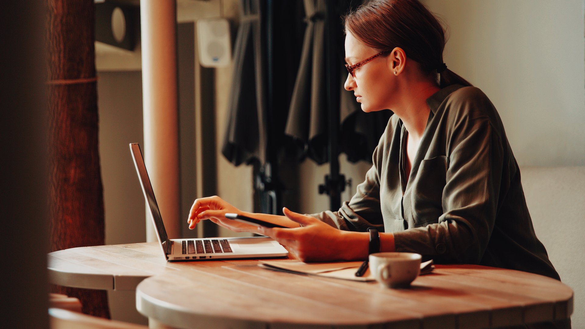 Coach comparing all-in-one platform options for her business, working through the decision over coffee.