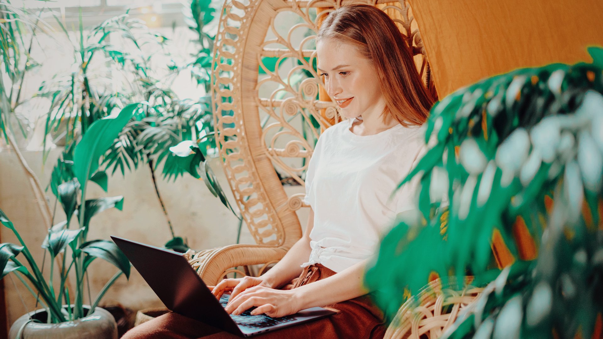 Business owner happily settled at her laptop at home after switching website platforms without losing anything.