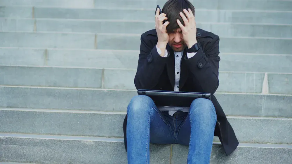 Man sitting with his head in his hands after losing his temper, understanding anger issues in men