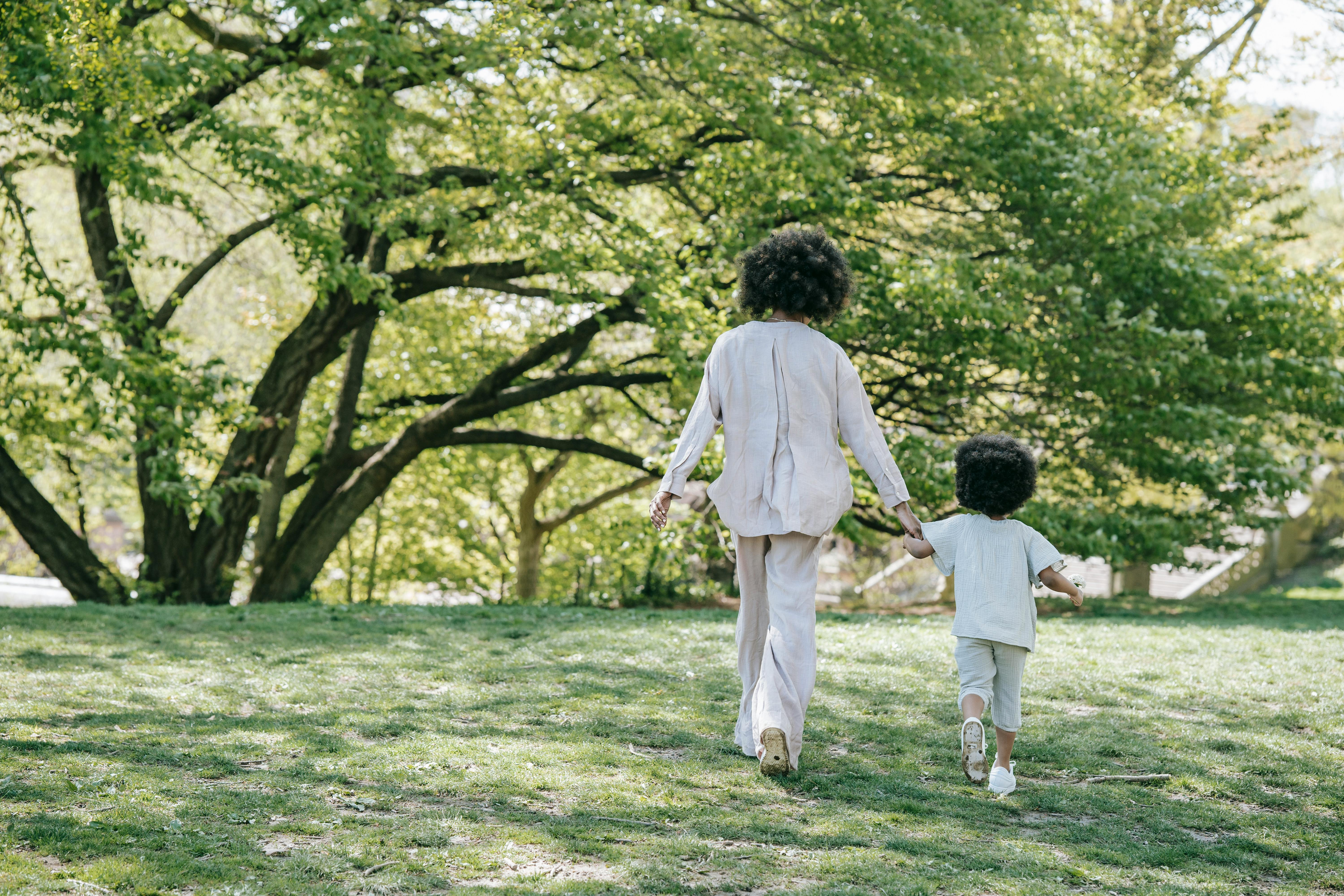 mother and child walking on grass