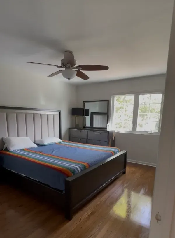Neat and refreshed bedroom after standard cleaning with made bed and dust-free furniture.