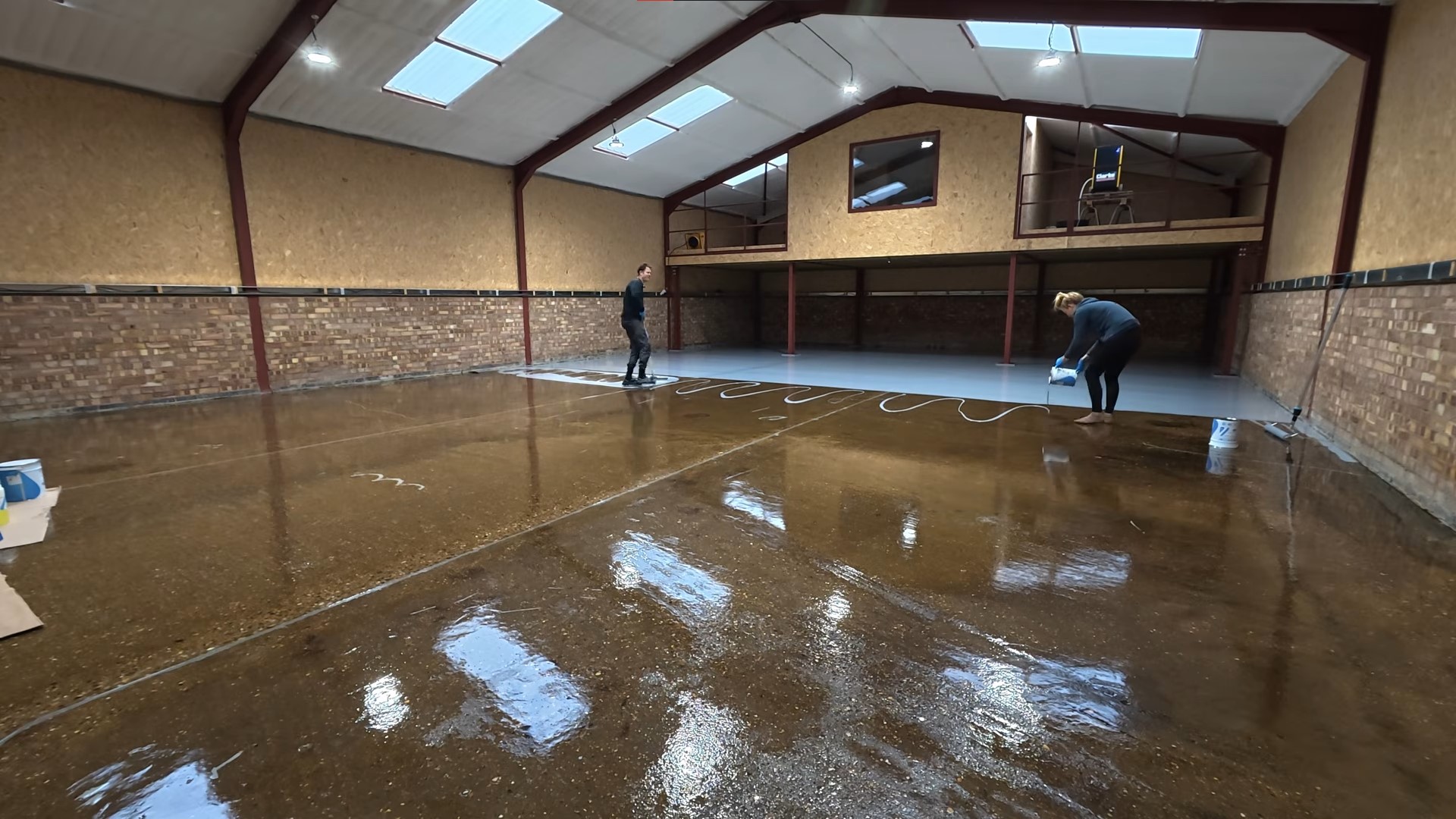grey epoxy base coat being applied on top of a sealant layer in a lobby