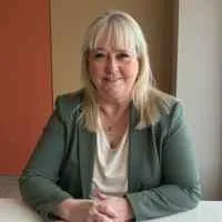 head shot of Kimberly Meyer looking at the camera with her hands clasped in front of her