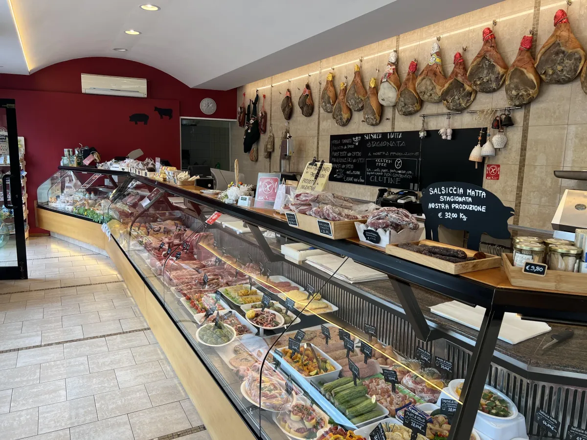Banco macelleria con tagli scelti, salumi appesi e preparazioni fresche di Centro Carni Forlì