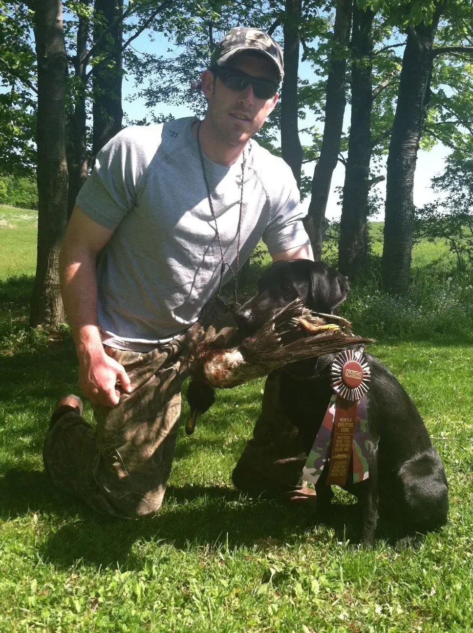 Black Labrador retriever with 1st place ribbon and owner, Dennis Tyler