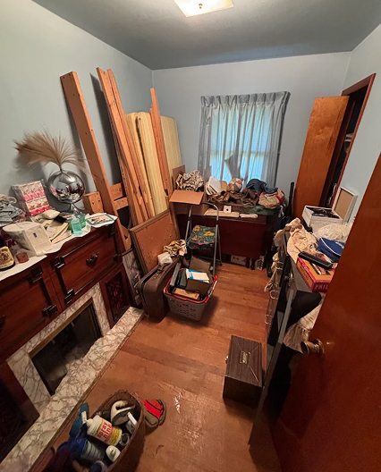 Cluttered spare room filled with furniture, boxes, and household items before a professional junk removal cleanout