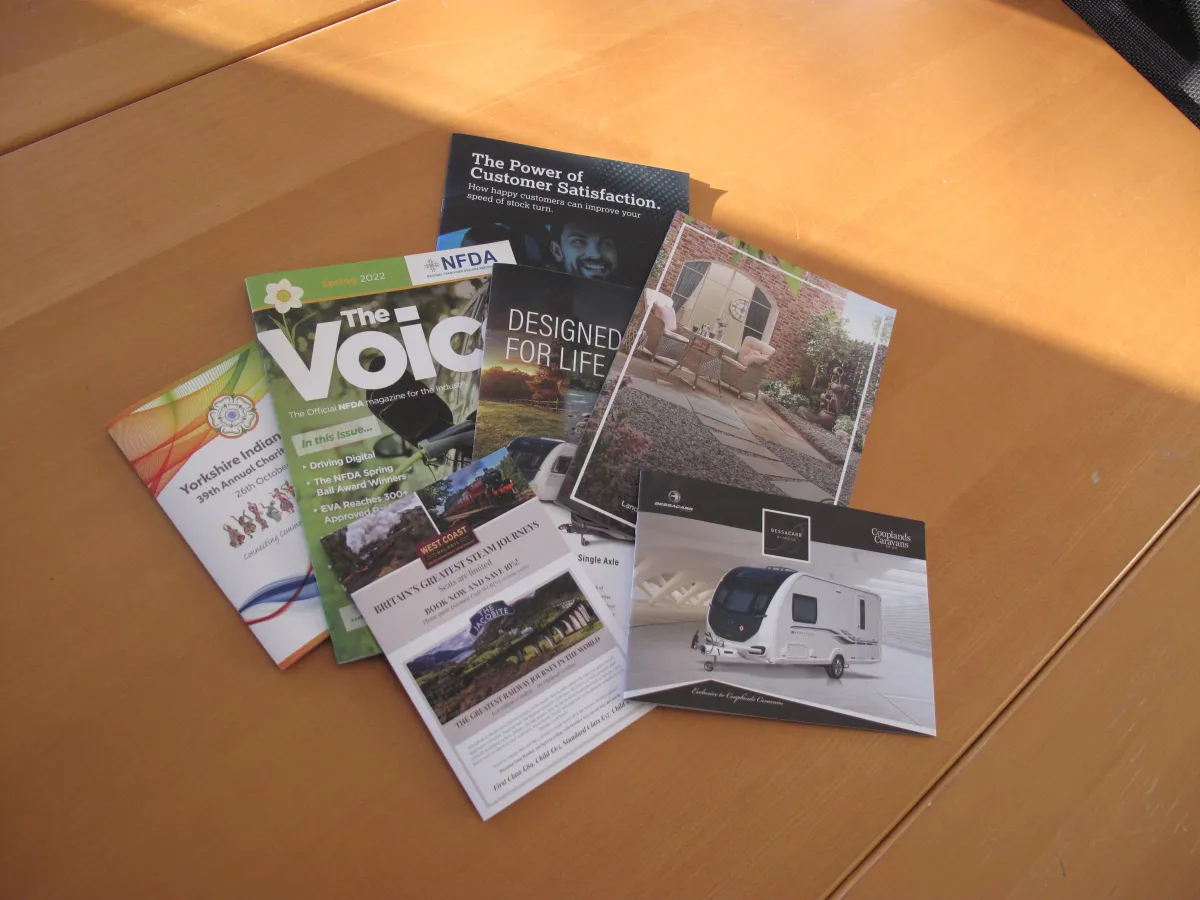 Colourful display of a range of magazines and leaflets on a wooden table top