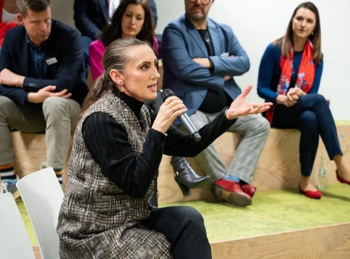 	Jeanette Okwu speaking on an AI panel with a microphone