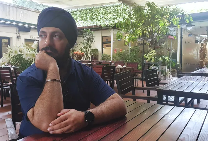 Dev Singh man wearing turban pondering in a restaurant