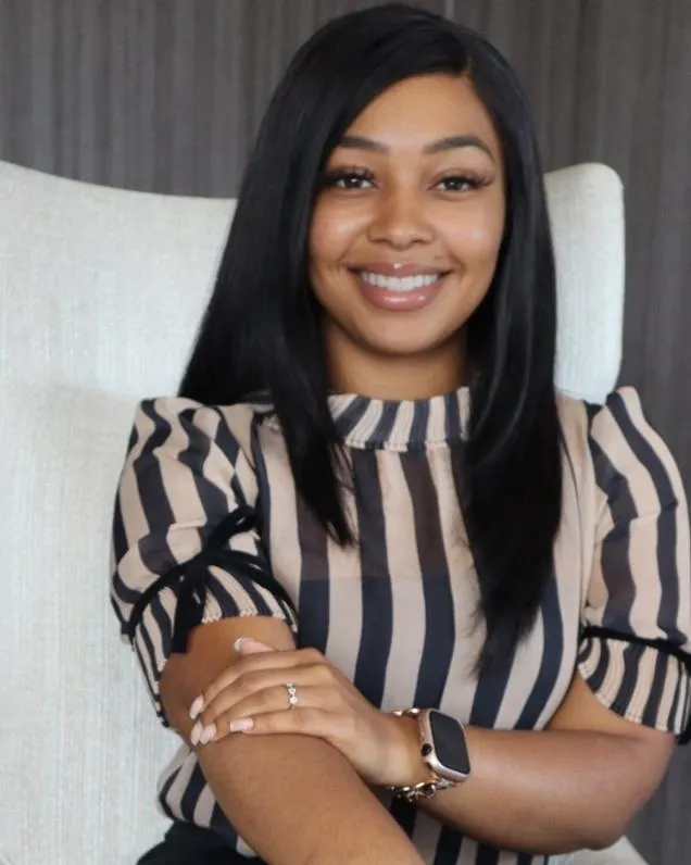 A round, pleated handbag with a dark plaid pattern.