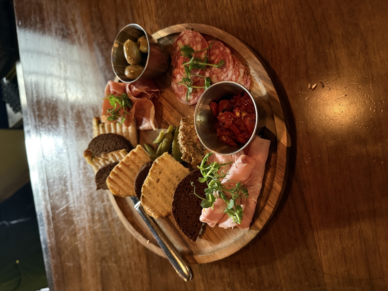 Charcuterie board with cured meats, olives, crackers and pepper jam at Uptown Tap & Cigar