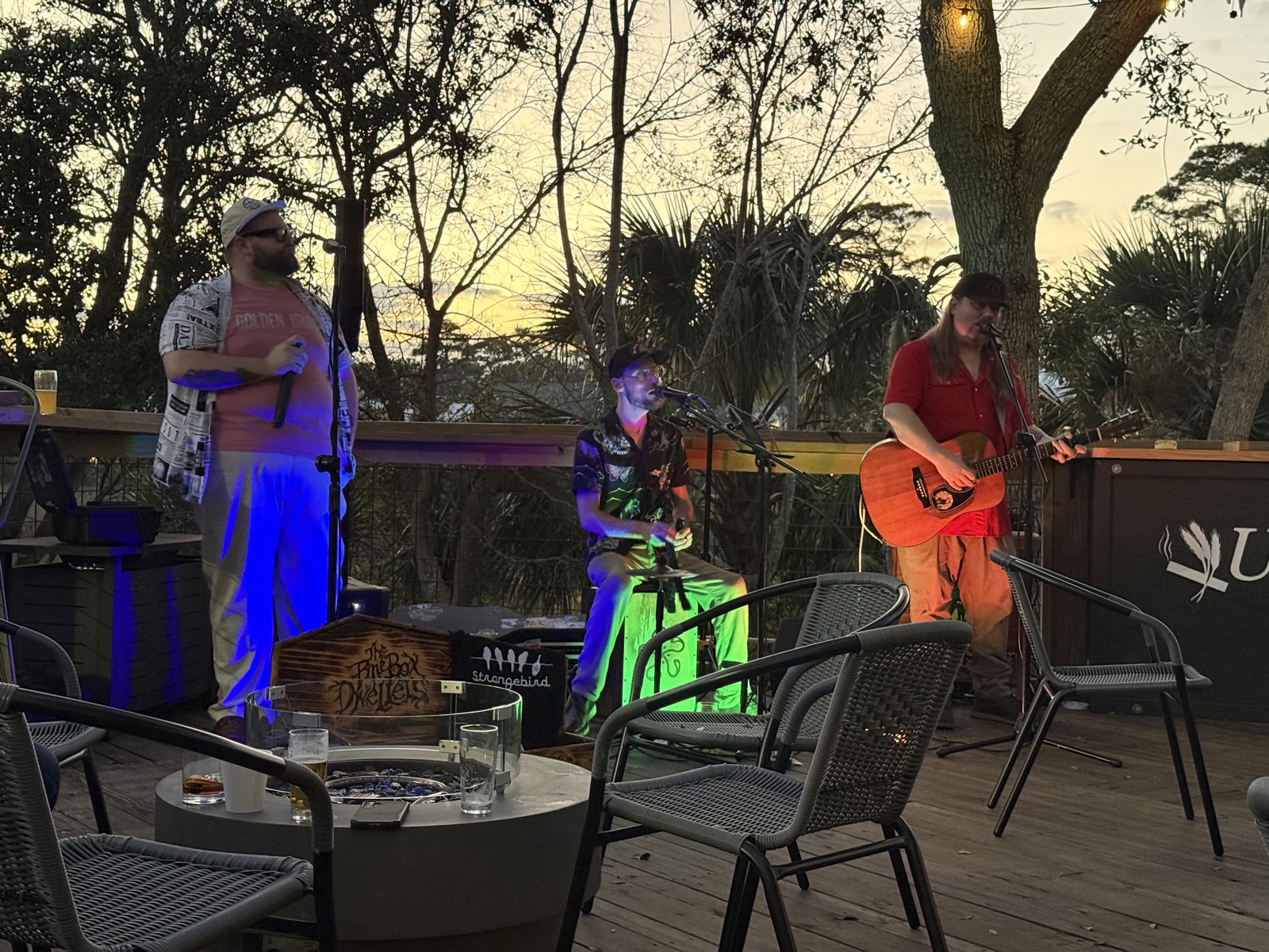 Live band playing on the marsh-front deck at Uptown Tap & Cigar at dusk