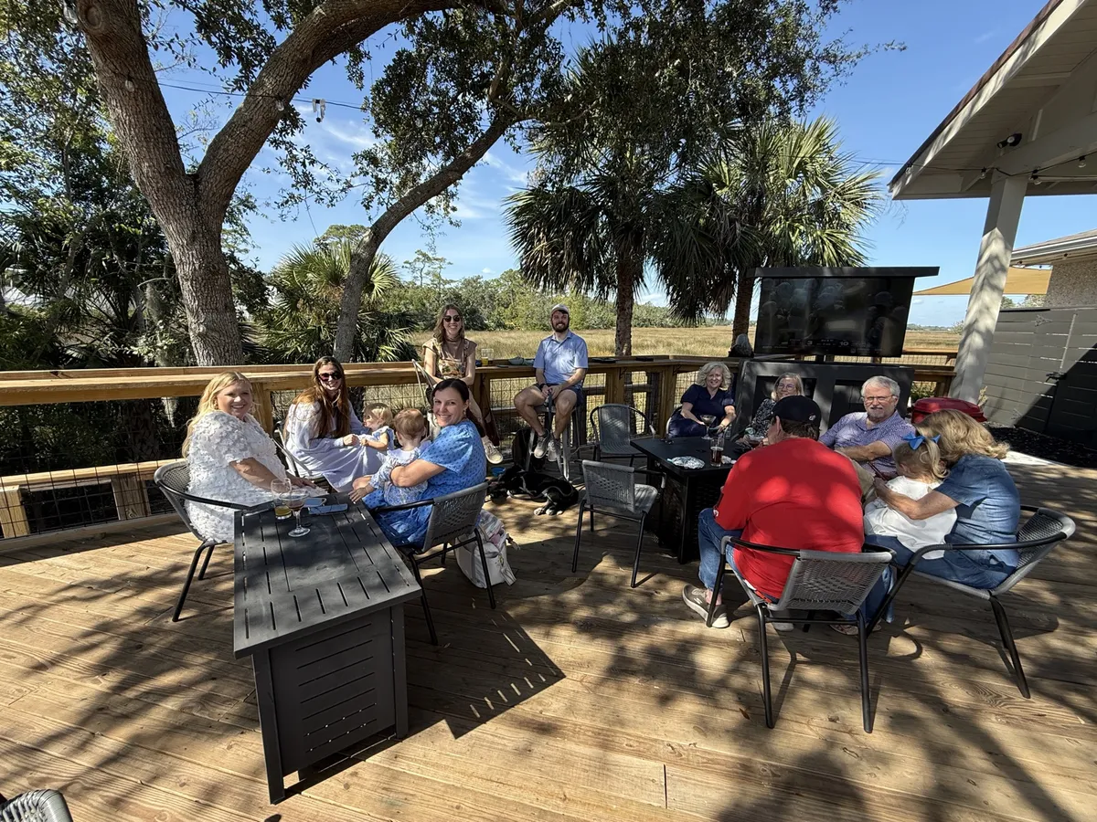 Friends gathered at deck tables at Uptown Tap & Cigar