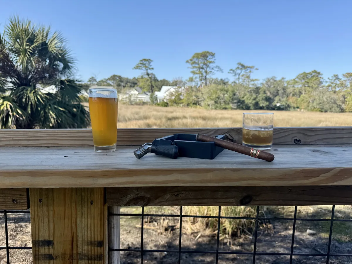 Two drinks and a cigar on the deck rail overlooking the marsh.
