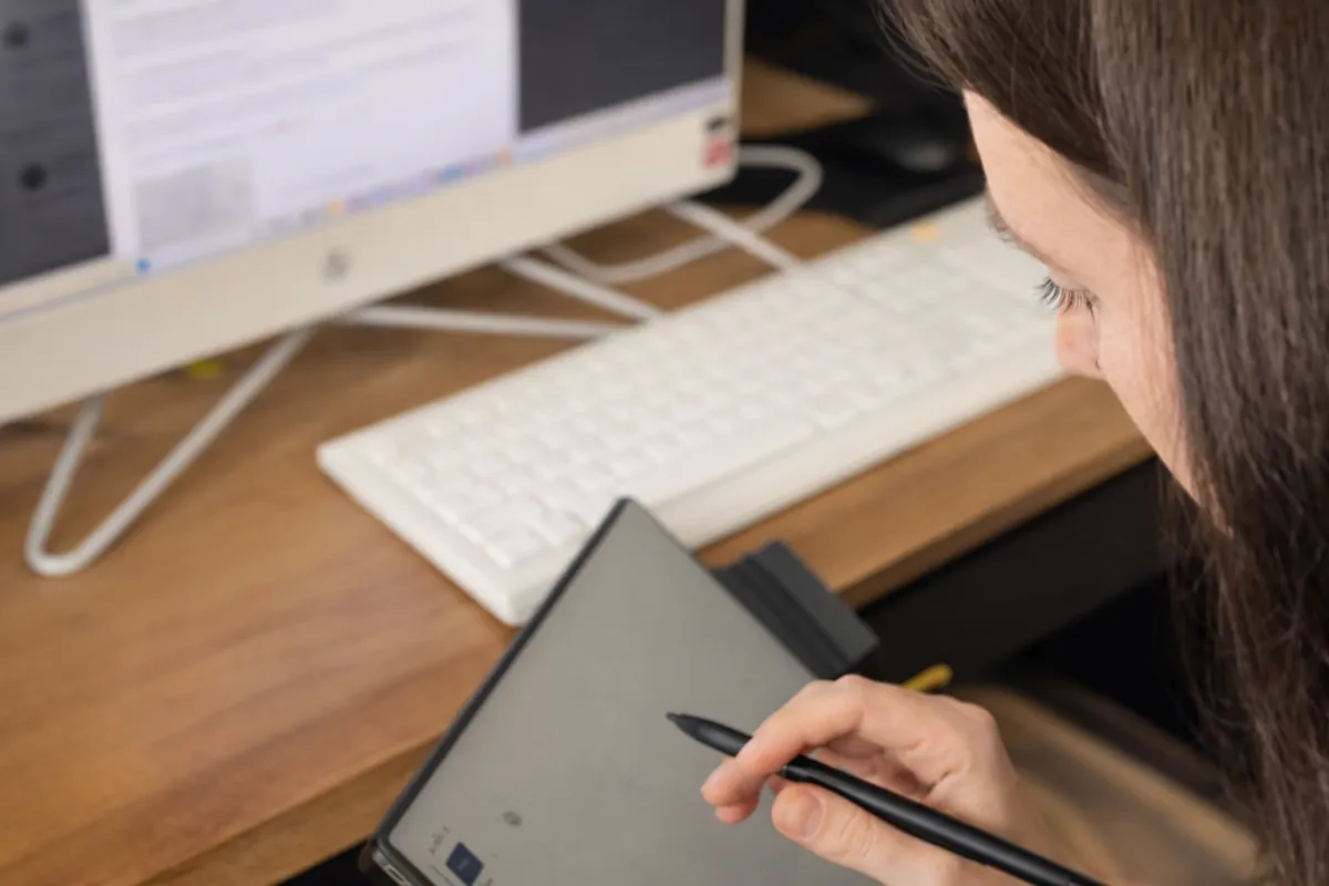 Jessica Paxton writing on her tablet near her computer