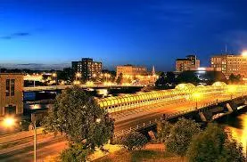 Nighttime cityscape with illuminated buildings, roads, and traffic lights creating a vibrant urban atmosphere.