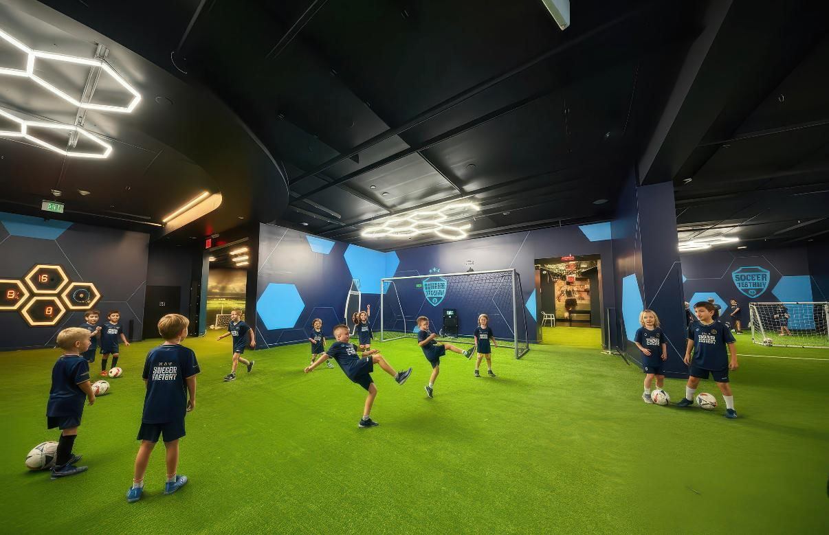 Kids playing soccer with a coach during practice