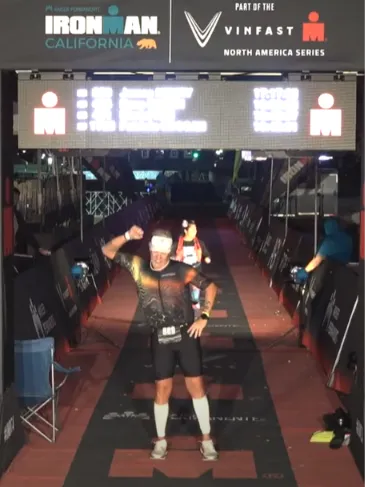 James Henry finishing Ironman California under the finish-line lights
