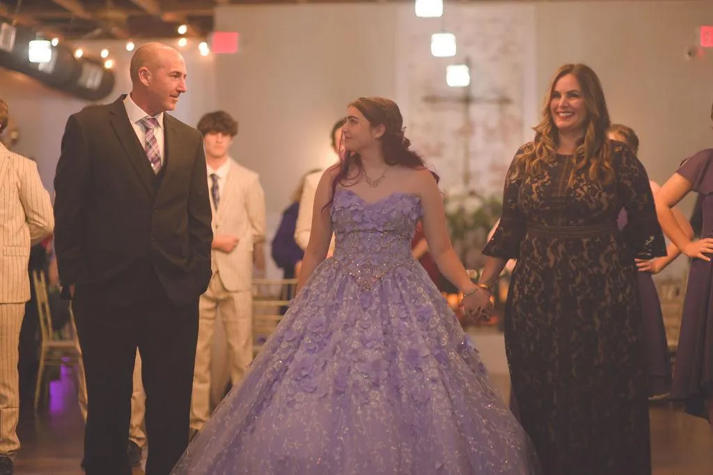XO Weber with her daughter and husband smiling during her quinceañera presentation